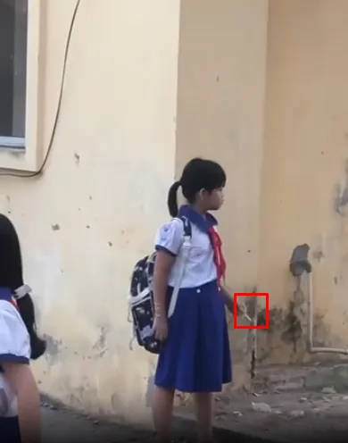 Học sinh tiểu học hút thuốc trong sân trường
